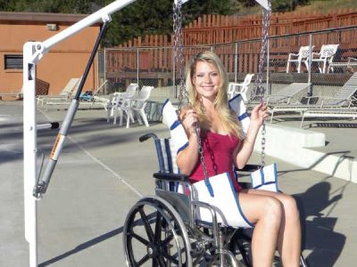 EZ2 pool lift shown next to pool, with sling attachment being used for wheelchair user